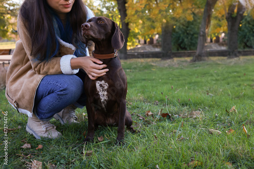 Woman with her German Shorthaired Pointer dog in park. Space for text © New Africa