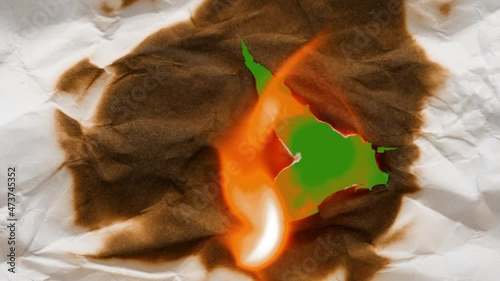 Spectacular video transition. A crumpled sheet of white paper catches fire from the center outward. Ready for use in the project. Green background isolated