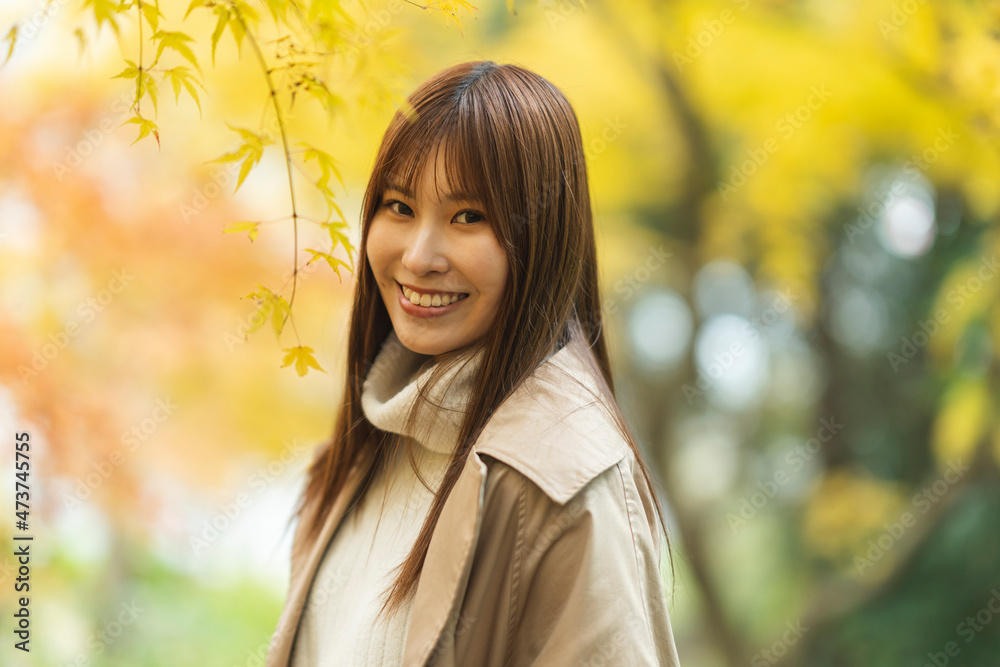 紅葉の公園にいる女性