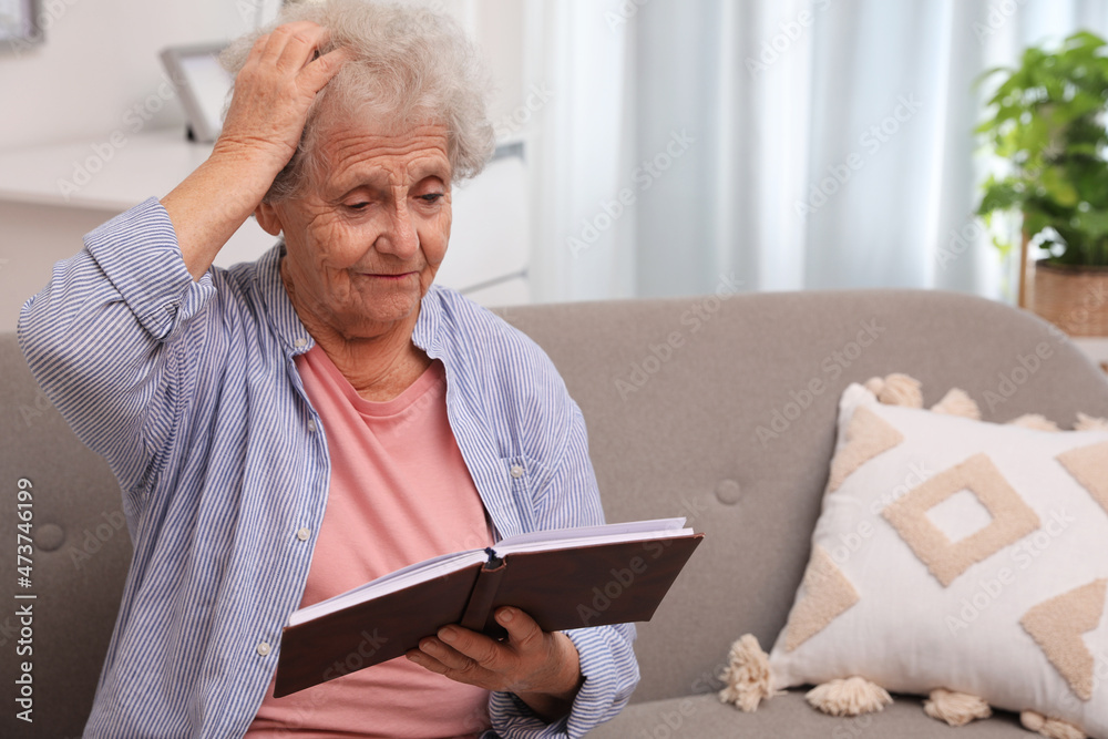 Senior woman with notebook at home, space for text. Age-related memory impairment Senior woman with notebook at home, space for text. Age-related memory impairment
