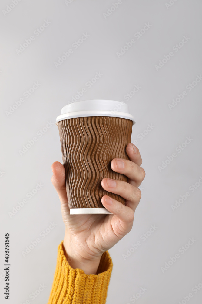 Woman holding takeaway paper coffee cup on white background, closeup Woman holding takeaway paper coffee cup on white background, closeup