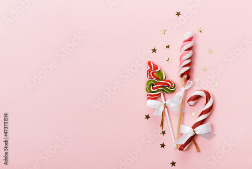 Christmas ornaments and decorations. Golden stars and red baubles on pink background. Minimal flat lay photo