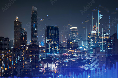 Stock market graph hologram, night panorama city view of Bangkok, popular location to gain financial education in Southeast Asia. The concept of international research. Double exposure.