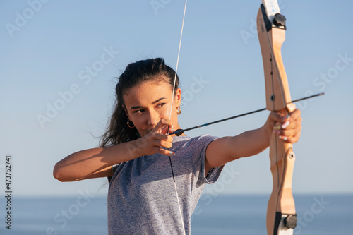Archeress aiming with bow and arrow