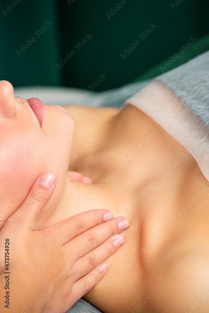 Massaging female neck. Young caucasian woman receiving neck massage relaxing in spa salon Massaging female neck. Young caucasian woman receiving neck massage relaxing in spa salon