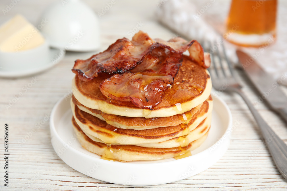Delicious pancakes with maple syrup and fried bacon on white wooden table, closeup Delicious pancakes with maple syrup and fried bacon on white wooden table, closeup