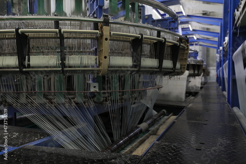 The mechanical equipment of the plastic weaving production line is running in a factory © zhang yongxin
