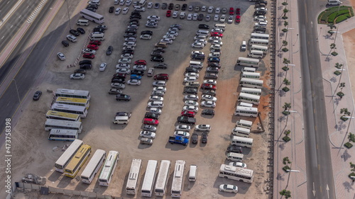 Big parking lot in downtown crowded by many cars and buses timelapse aerial view.