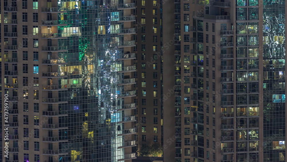Big glowing windows in modern residential buildings timelapse at night