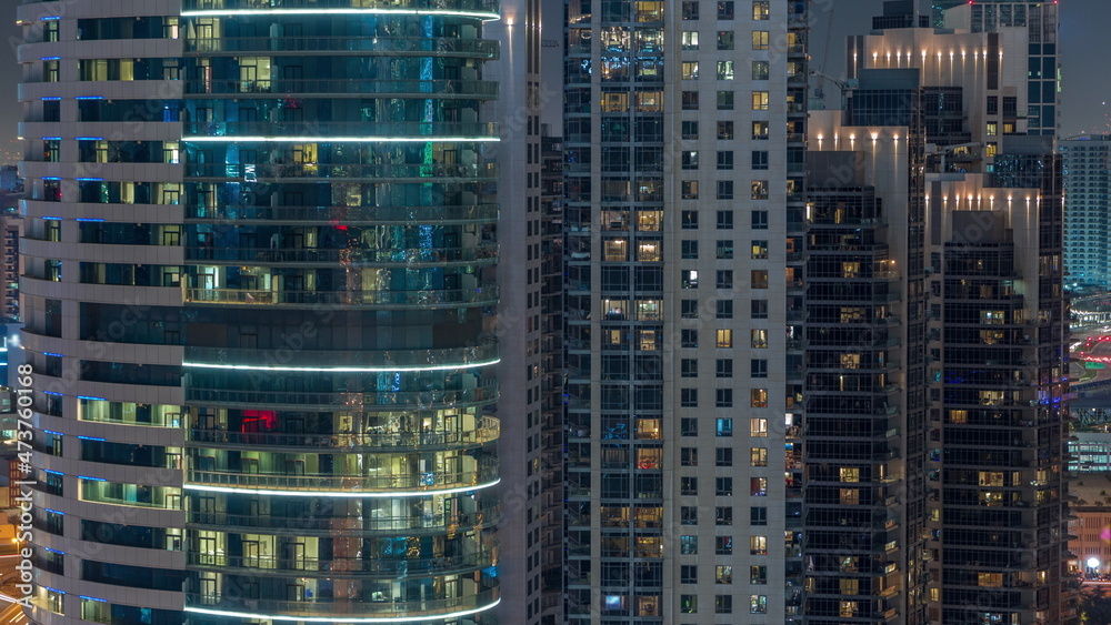 Big glowing windows in modern office and residential buildings timelapse at night