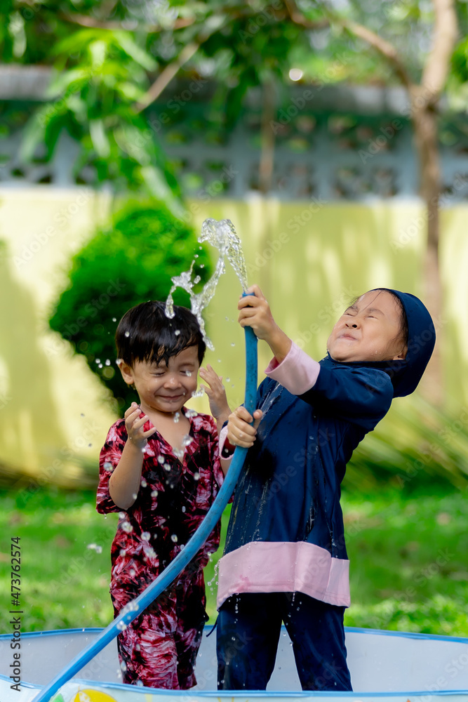 Asian Boy And Girl Take A Bath In The Tub In The Front Yard Stock Photo