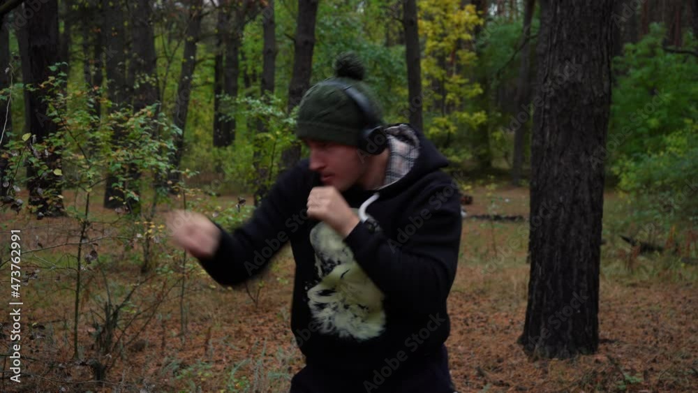 male fighter is training in the morning forest. a fight with a shadow. 4k footage male fighter is training in the morning forest. a fight with a shadow. 4k footage