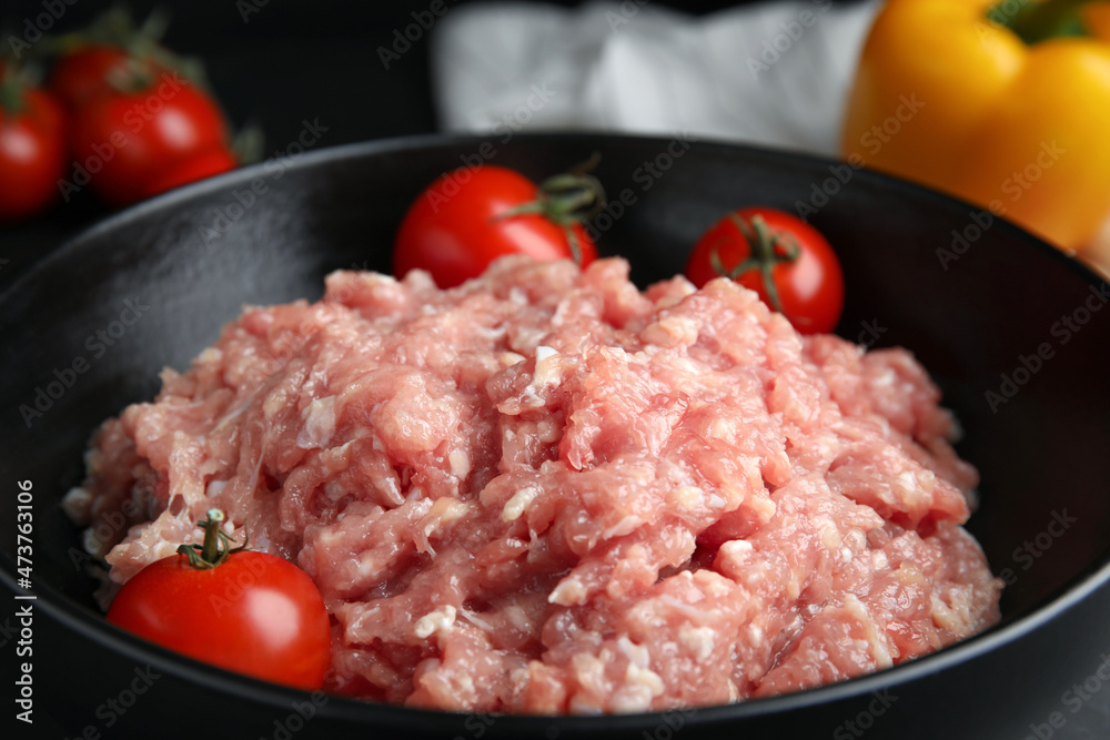 Raw chicken minced meat with tomatoes in bowl, closeup Raw chicken minced meat with tomatoes in bowl, closeup