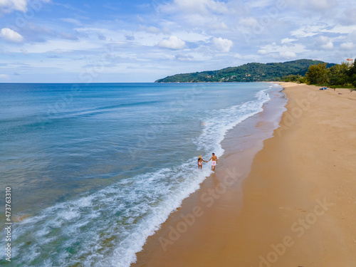 Karon Beach Phuket Thailand, couple man and women walking at a tropical beach during a luxury vacation in Thailand.  photo