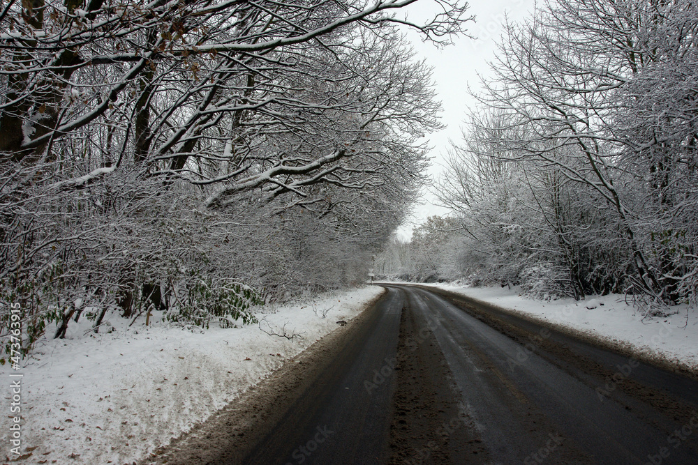 Icy and snowy weather, hazardous road and driving conditions, rural country road Icy and snowy weather, hazardous road and driving conditions, rural country road