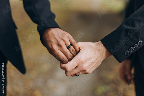 European Gay Couple holding hands, homosexual marriage wedding day. Gentle touch of a same sex couple