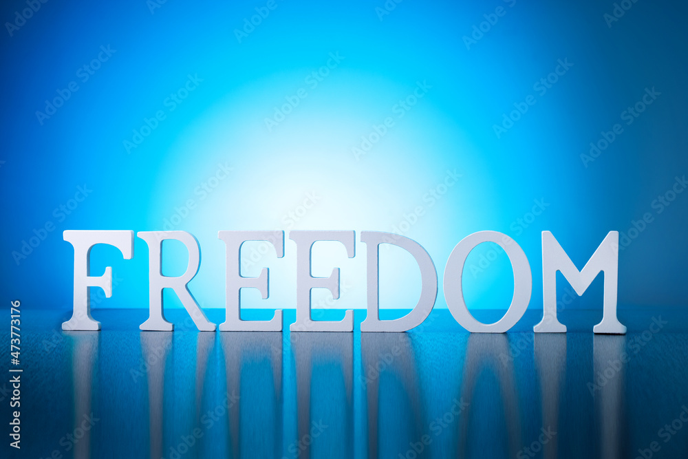 Freedom concept with FREEDOM word on blue background.