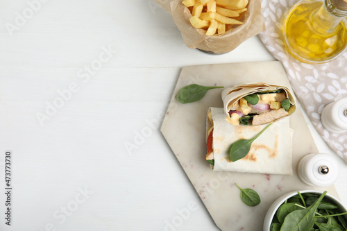 Delicious shawarma with chicken and fresh vegetables served on white wooden table, flat lay. Space for text