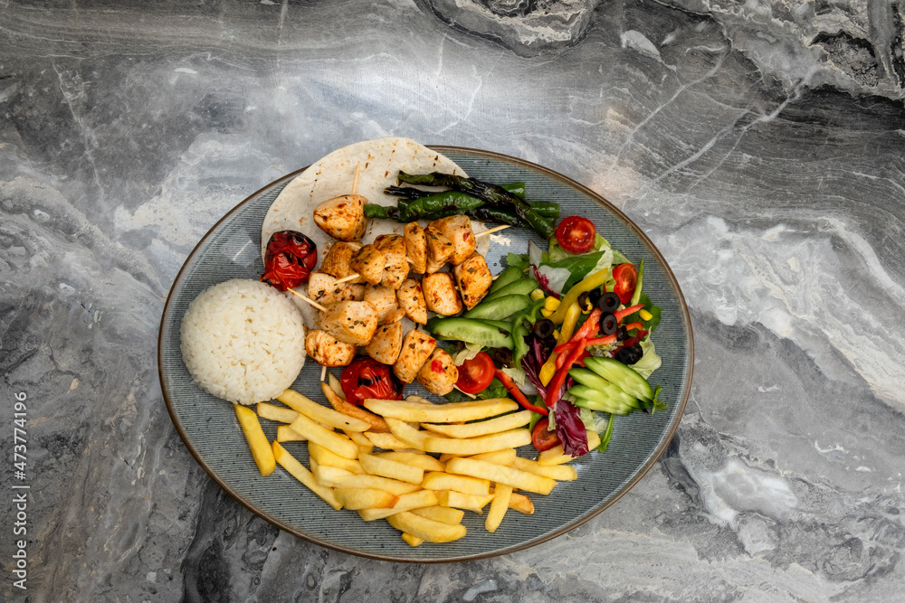 grilled chicken in a serving plate on a marble floor