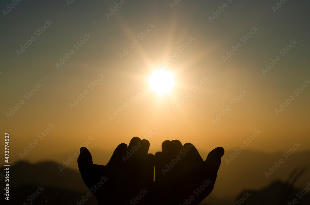 Human's hands pray on blurred light background , soft focused