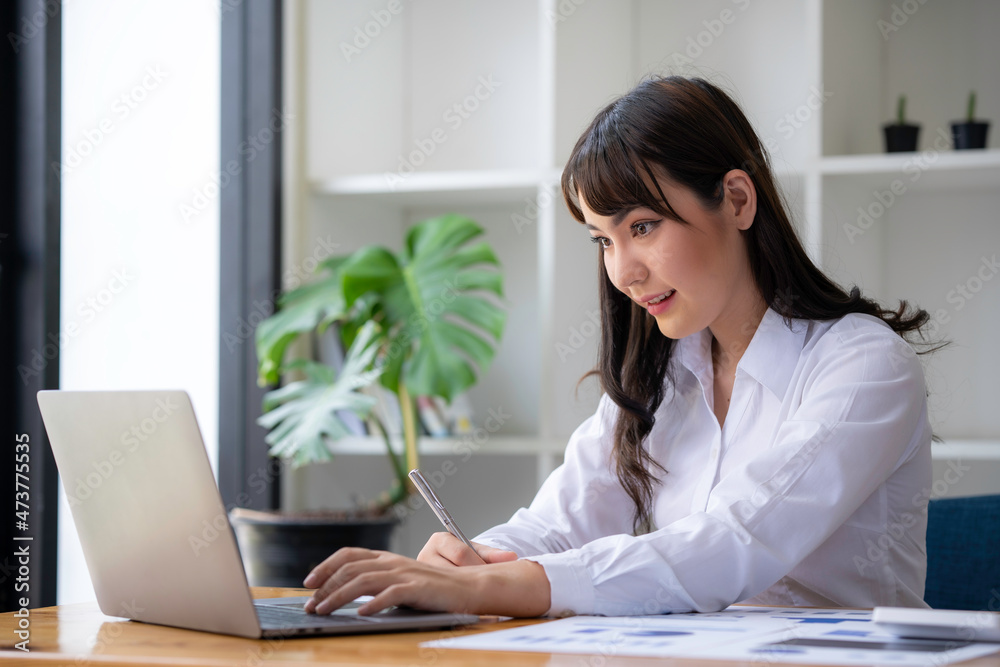 Portrait of a businesswoman typing on laptop preparing report analyzing work results, female executive doing paperwork at the workplace using a computer online for data Portrait of a businesswoman typing on laptop preparing report analyzing work results, female executive doing paperwork at the workplace using a computer online for data