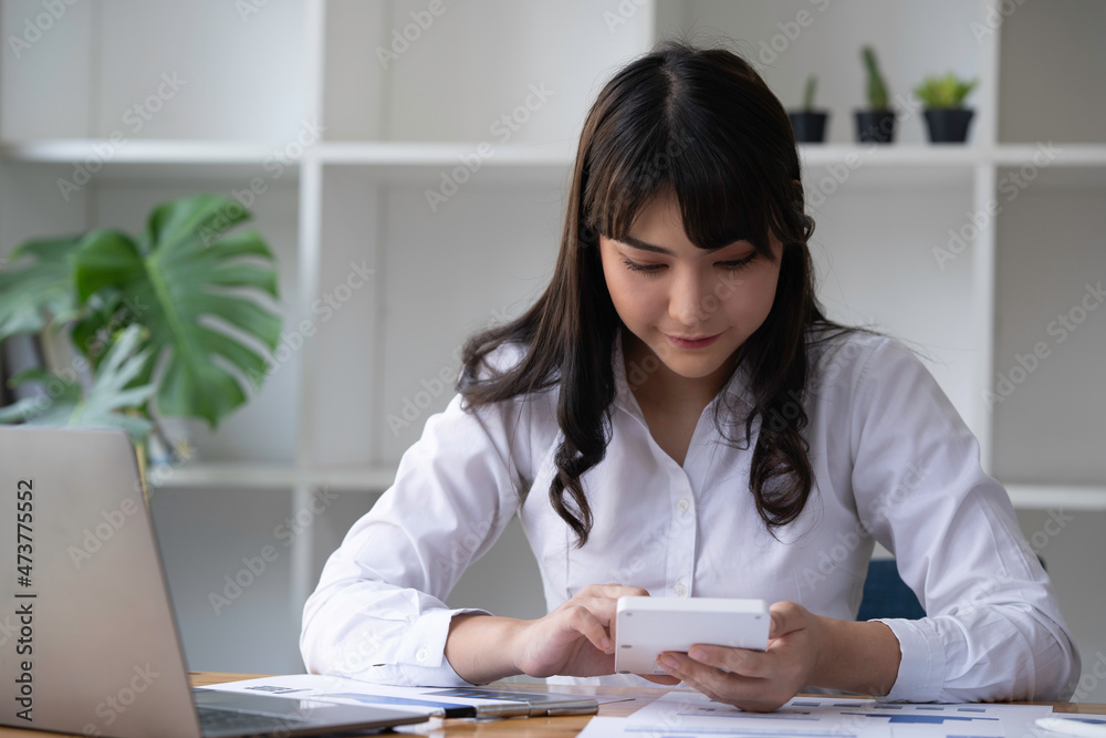 Portrait of a Business accounting concept, Businesswoman using a calculator with computer laptop, budget, and loan paper in the office. Portrait of a Business accounting concept, Businesswoman using a calculator with computer laptop, budget, and loan paper in the office.