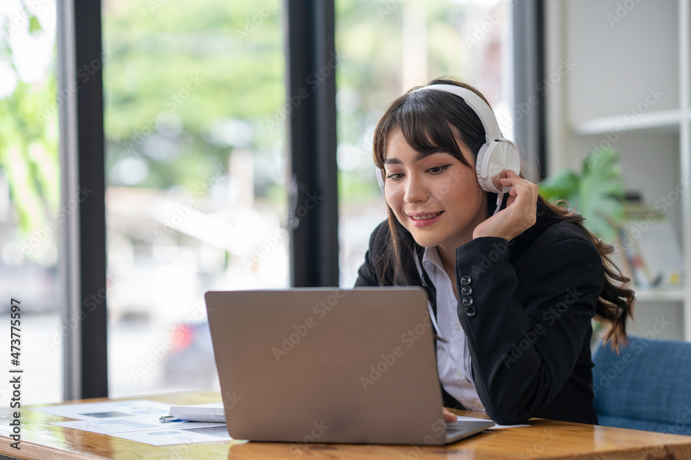 Portrait of a business woman happily wearing music headphones while working to relax after a hard day's work. Portrait of a business woman happily wearing music headphones while working to relax after a hard day's work.