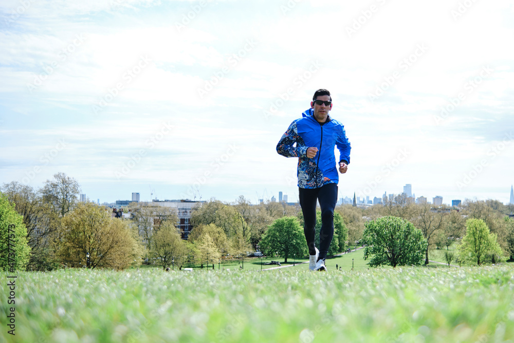Man wearing sunglasses running at public park during sunny day Man wearing sunglasses running at public park during sunny day