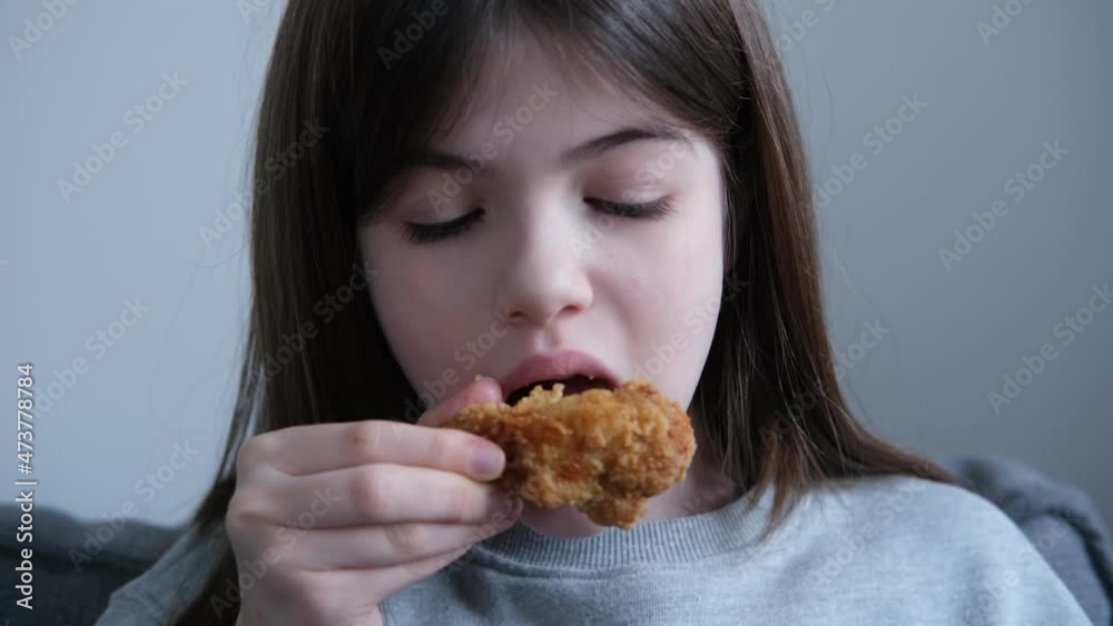 little girl, teenager eating a chicken leg, drumstick at home not healthy food, fast food concept little girl, teenager eating a chicken leg, drumstick at home not healthy food, fast food concept
