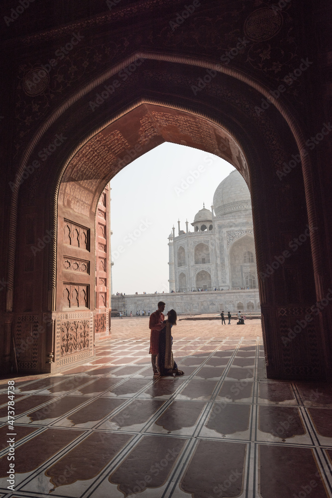 Romantic Couple near Taj Mahal. View in black arch silhouette from the mosque in Agra, Uttar Pradesh, India
