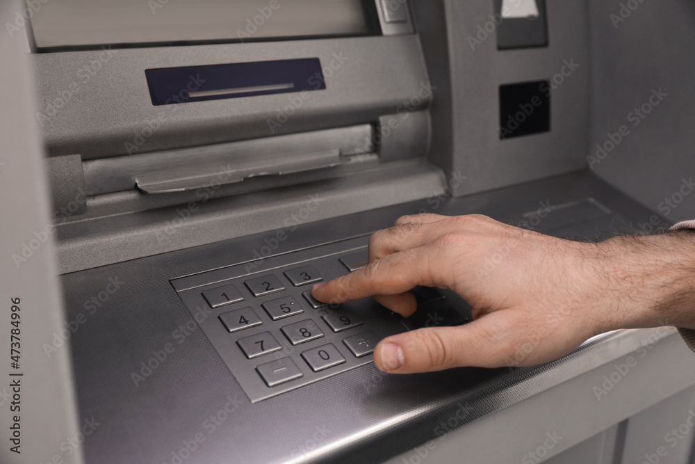 Man entering cash machine pin code, closeup Man entering cash machine pin code, closeup