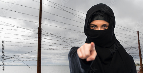 Tableau sur toile migration crisis, freedom and security concept - woman in hijab pointing finger