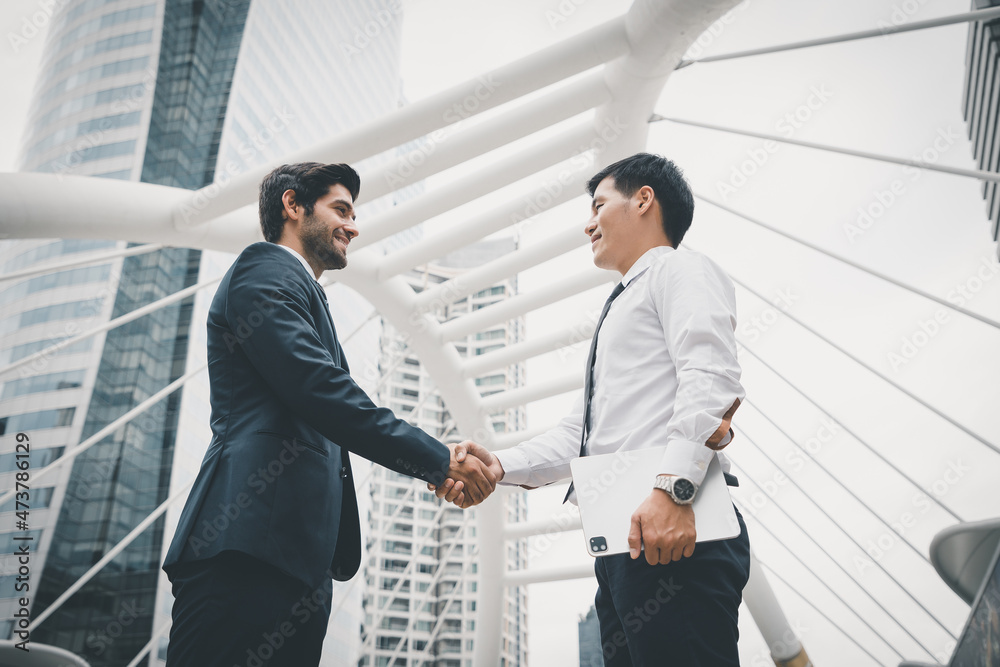 Businessman handshake and agreement with working outside the office to change his perspective of big projects. Investment ideas and business growth reporting from the archives. Businessman handshake and agreement with working outside the office to change his perspective of big projects. Investment ideas and business growth reporting from the archives.