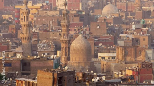 Zoom out shot of islamic quarter of Cairo with houses and mosques. Birds fly against background of mosque and minarets in Cairo, Egypt photo