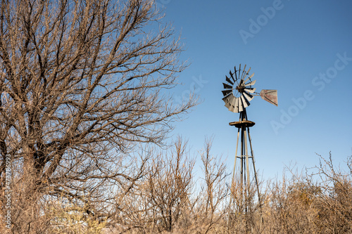 Old Water Pump Windmill Sits Among Bare Trees