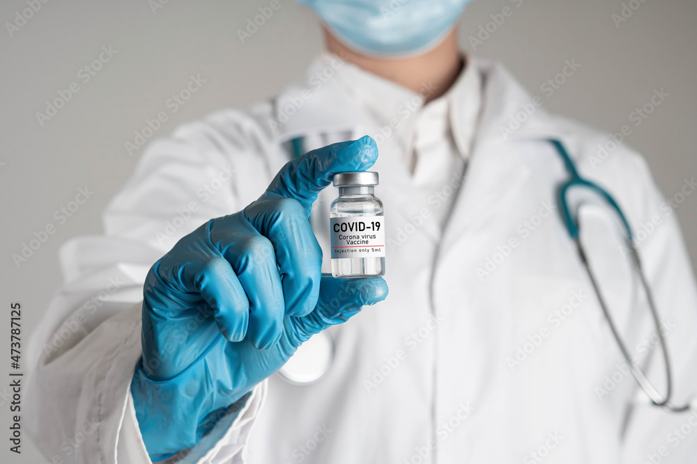 Female doctor with stethoscope on shoulder holding bottle of Coronavirus, covid 19 virus, covid-19 vaccine bottle, health care and medical concept. Female doctor with stethoscope on shoulder holding bottle of Coronavirus, covid 19 virus, covid-19 vaccine bottle, health care and medical concept.