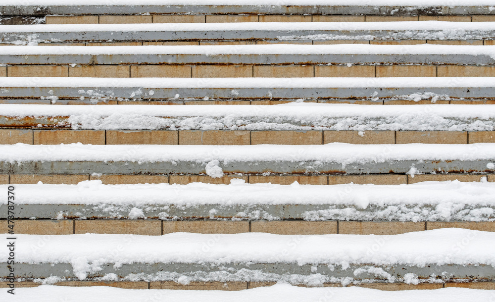 The upward stone staircase is covered with freshly fallen white snow.