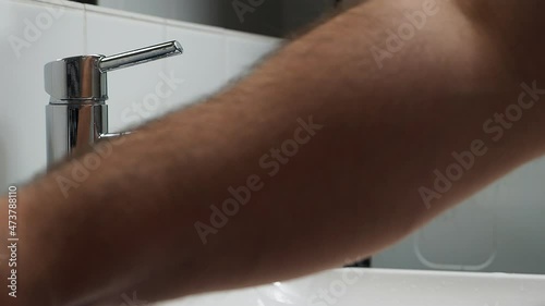 The man washes his hands with soap. photo