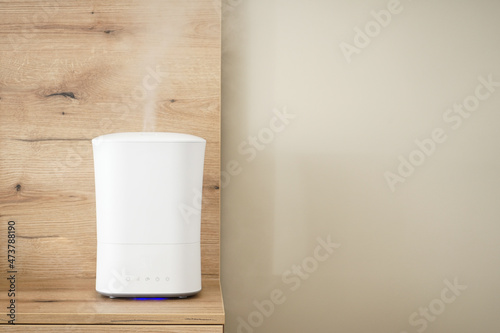 Modern air humidifier on the bedside table in the bedroom  space for text.