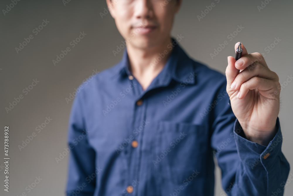 Business man, trader, investor hold pen, pointing to empty copy-space to choose business strategy planning, money trade, business invest with grey background. Business trade and investment concept.