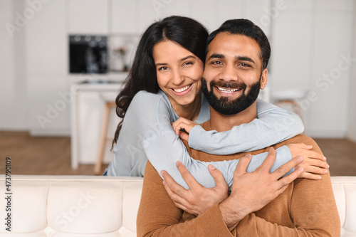 Fotografi Happy lovely young Indian couple together at home, ethnic young wife hugging fro