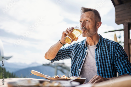 Man drinking beer while sitting at restaurant