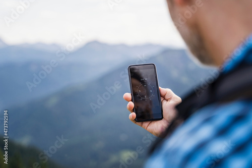 Male hiker searching direction through mobile phone photo