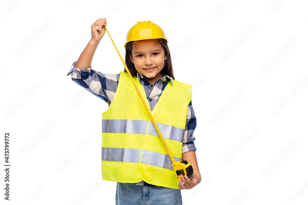 building, construction and profession concept - smiling little girl in protective helmet and safety vest with ruler over white background