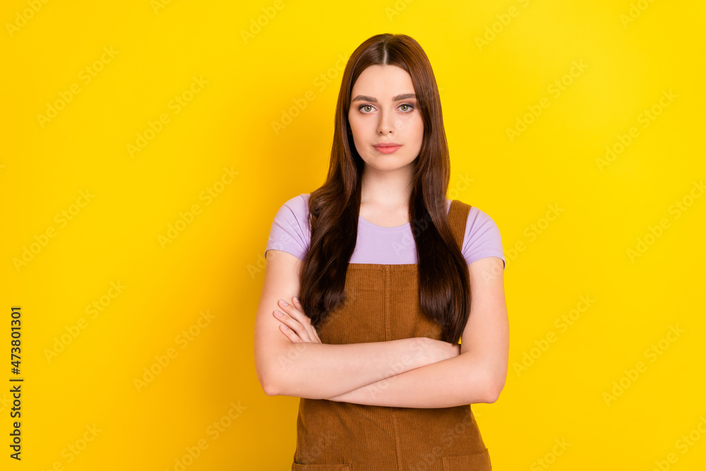 Portrait of attractive content brown-haired girl folded arms isolated over vibrant yellow color background Portrait of attractive content brown-haired girl folded arms isolated over vibrant yellow color background