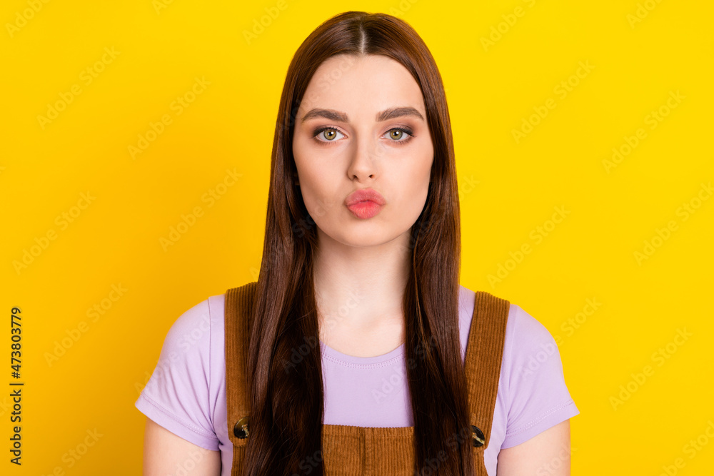 Portrait of attractive amorous brown-haired girl sending air kiss isolated over bright yellow color background Portrait of attractive amorous brown-haired girl sending air kiss isolated over bright yellow color background