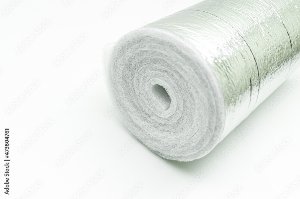 A roll of insulation made of foamed polyethylene with aluminum foil. Thermal insulation with reflective foil. Selective focus, copy space A roll of insulation made of foamed polyethylene with aluminum foil. Thermal insulation with reflective foil. Selective focus, copy space