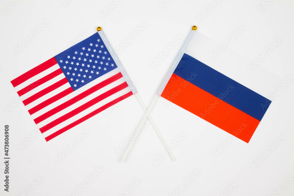 USA flag and Russia flag crossed with each other on the white background. USA vs Russia. Meeting between the presidents of the United States and Russia summit. Isolated. Top view USA flag and Russia flag crossed with each other on the white background. USA vs Russia. Meeting between the presidents of the United States and Russia summit. Isolated. Top view