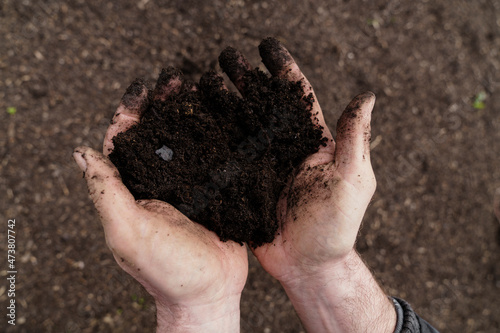 Mature man holding soil in hand