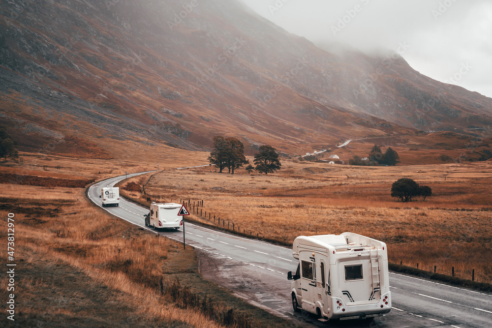 Motorhomes and tourists in Glencoe, Scotland on a long winding road - obrazy, fototapety, plakaty 